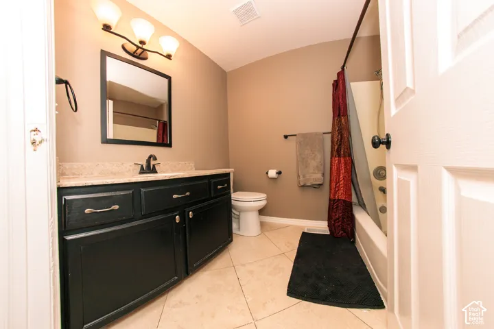 Black vanity with brushed nickel hardware, stone-finish countertop, and integrated sink