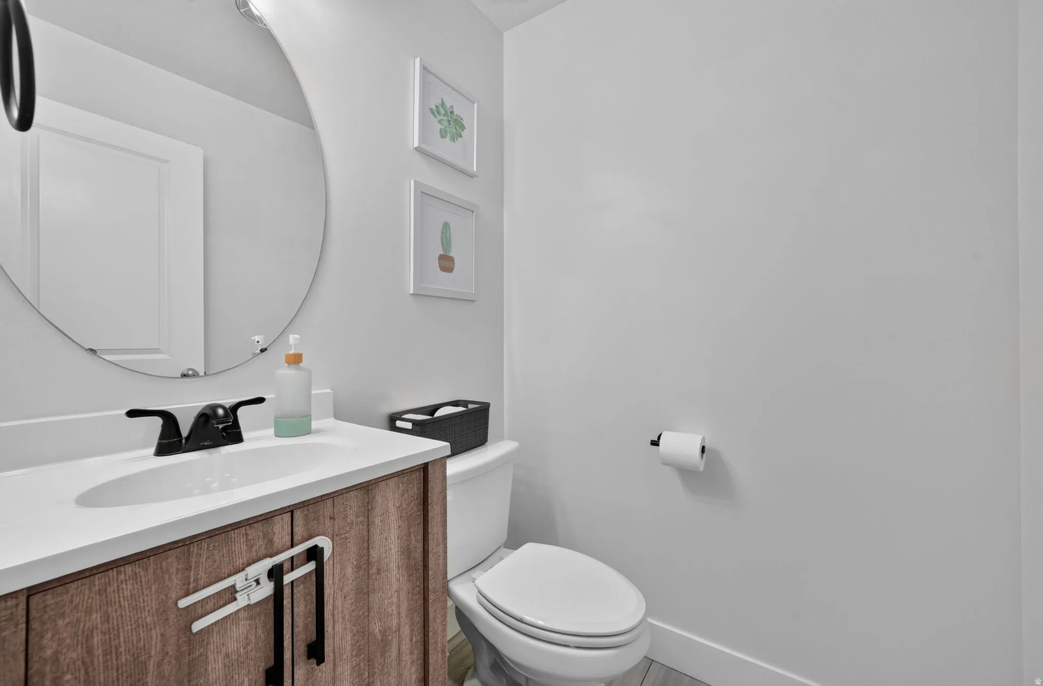 Bathroom vanity with a wood-finish cabinet, integrated sink, and dark-toned faucet
