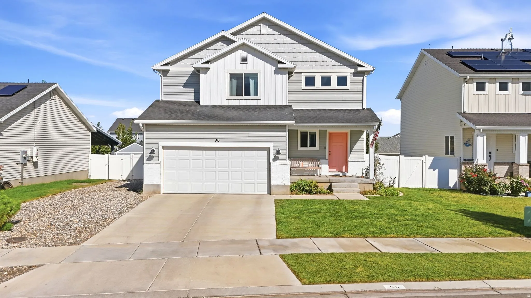 Two-story exterior with a covered porch, attached garage, and a concrete driveway