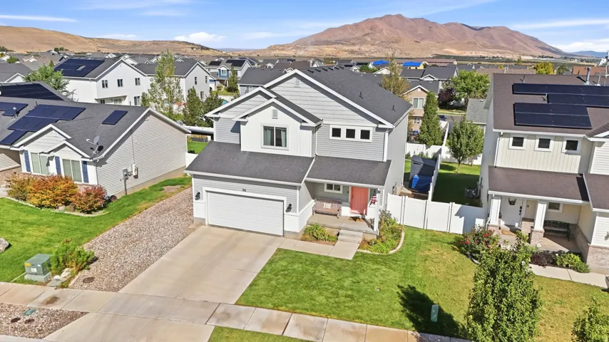 Contemporary two-story residence featuring a two-car attached garage, a well-maintained front lawn, and a paved driveway