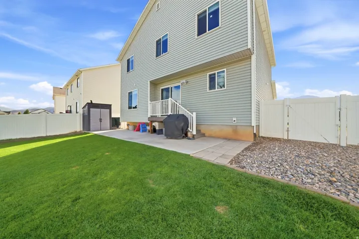 Expansive lawn with a paver patio and rock landscaping