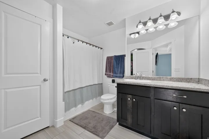 Double door vanity with ample storage, integrated sink, and stone-finish countertop