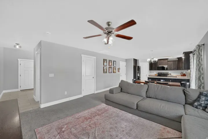 Open-concept living area featuring a ceiling fan, recessed lighting, and direct access to the kitchen