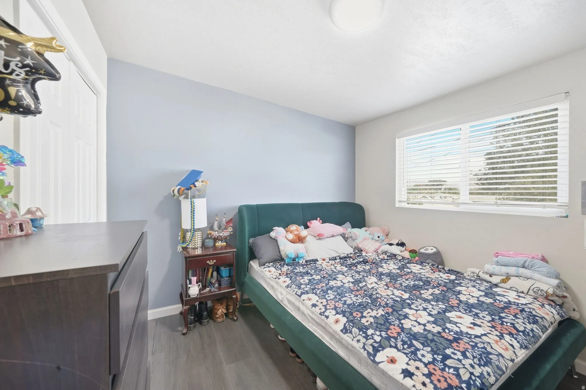 Recessed window with horizontal blinds, wood-finish flooring, and white interior doors