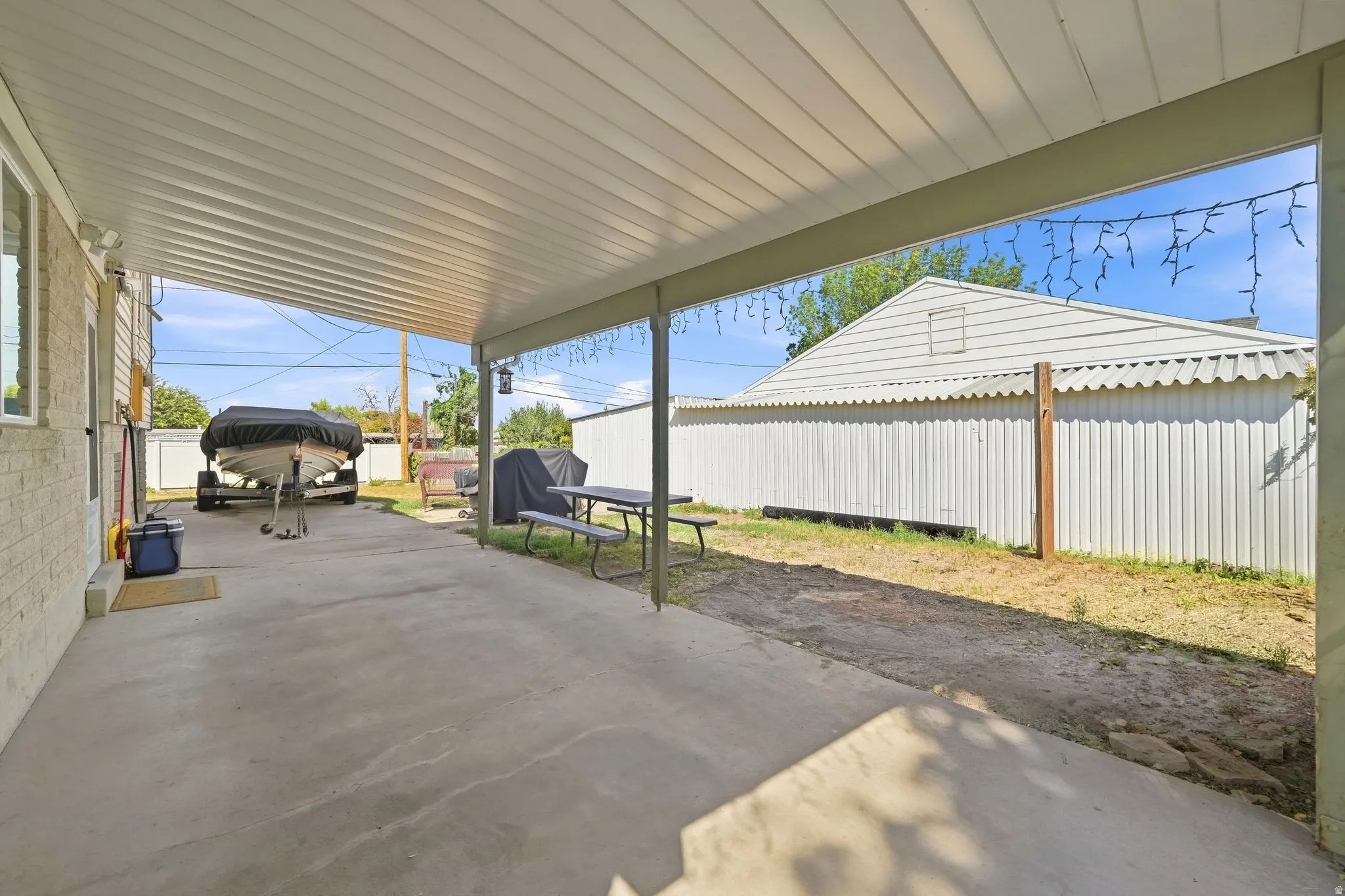 Covered concrete patio with a painted brick exterior wall