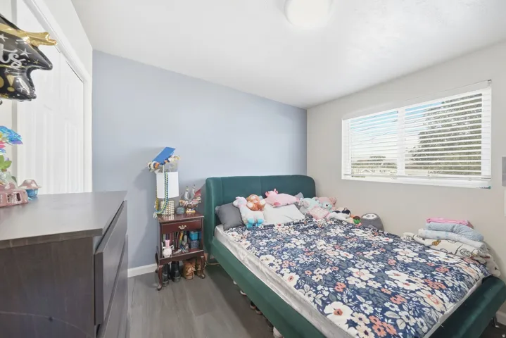 Recessed window with horizontal blinds, wood-finish flooring, and white interior doors