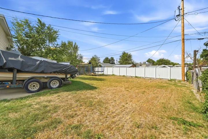 Expansive grass area with a white privacy fence