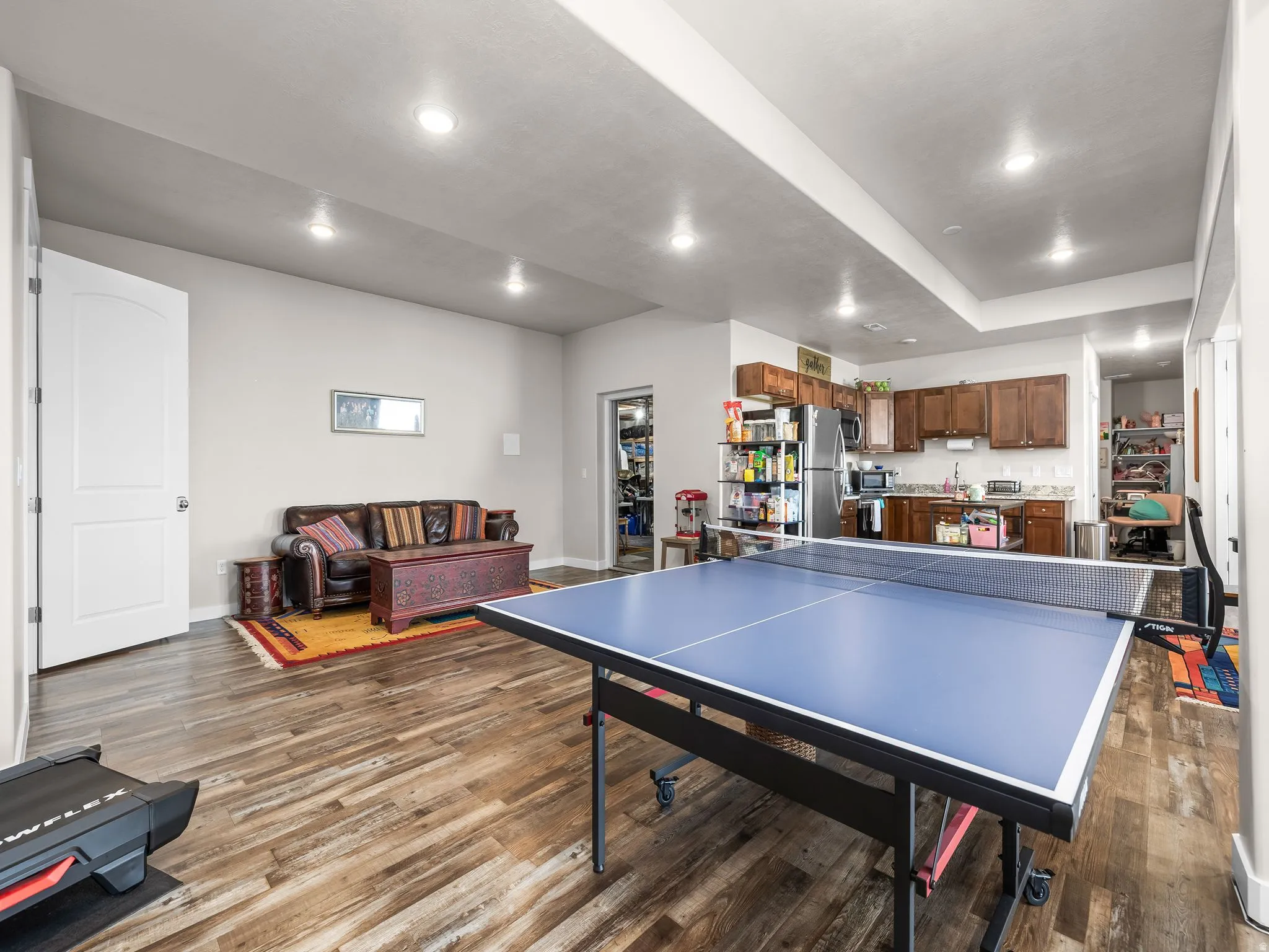 Recessed lighting, wood-finish flooring, wood cabinetry, built-in shelving, and stainless steel appliances