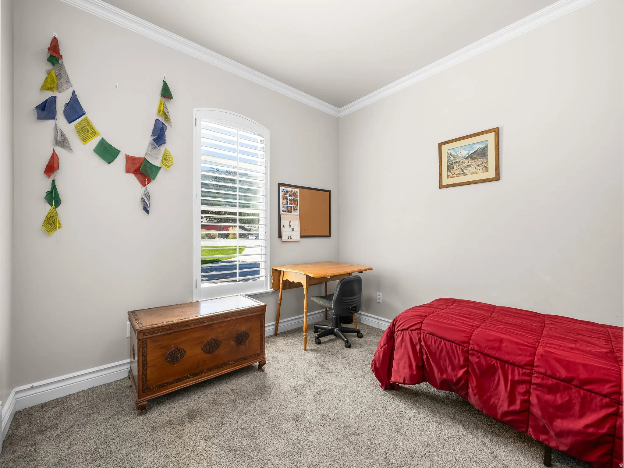 Arched window with plantation shutters, crown molding, white baseboards, and neutral wall color