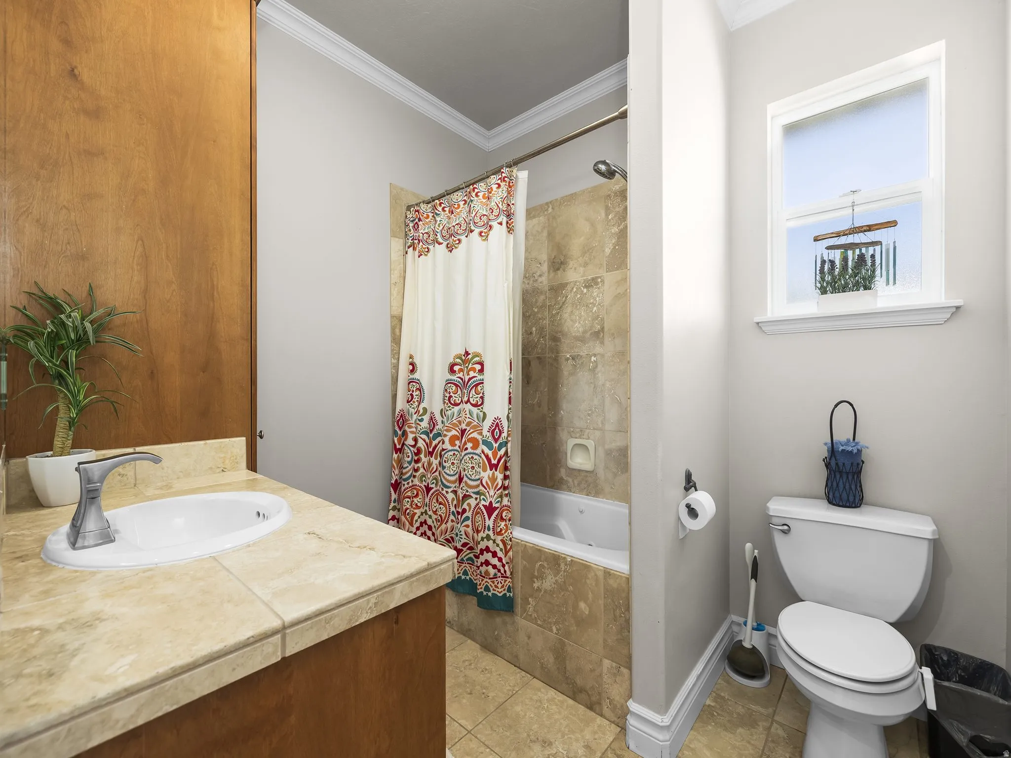 Bathroom featuring a single vanity with an integrated sink, a tiled countertop, and wood-finish cabinetry