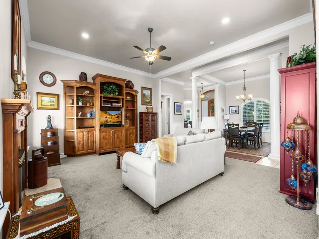 Living room featuring neutral-toned carpeting, a built-in entertainment center, and recessed lighting