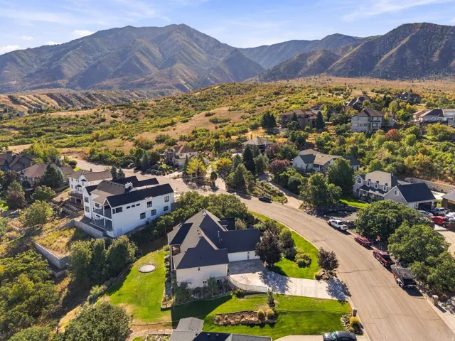 Mountainous backdrop, residential neighborhood setting, paved streets, varied architectural styles, mature trees and landscaping
