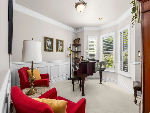 Bay window with plantation shutters, crown molding, chair rail with wainscoting, and recessed lighting