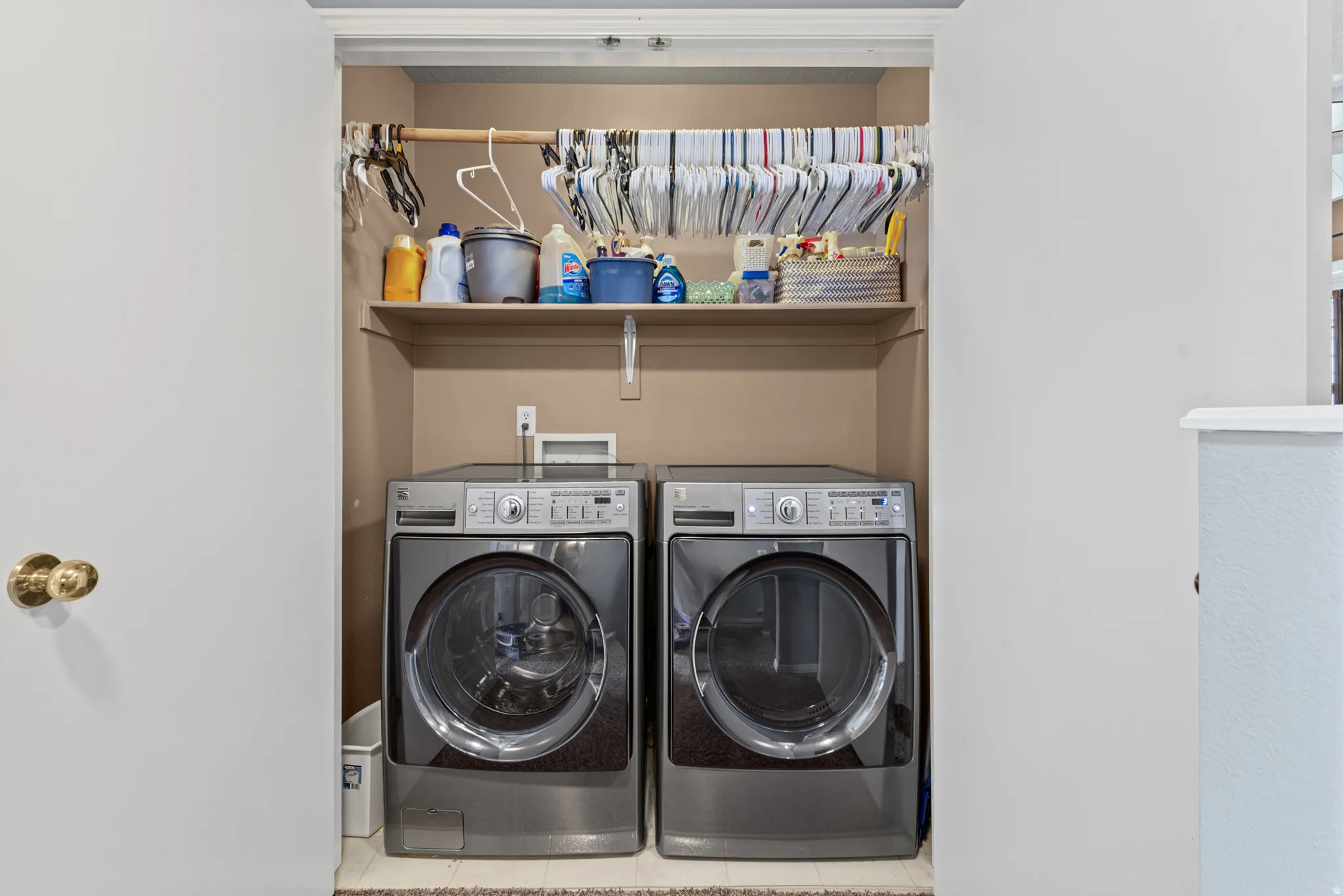 Dedicated laundry closet featuring a built-in shelf, hanging rod, and space for a washer and dryer