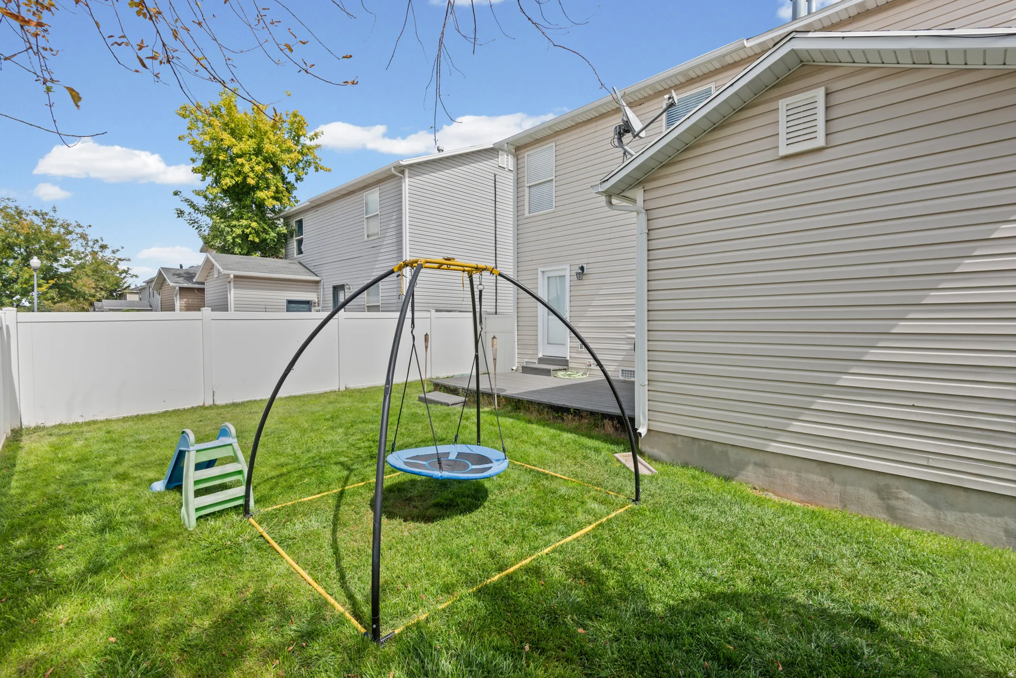 Fenced backyard featuring a manicured lawn, concrete patio, and light-colored siding