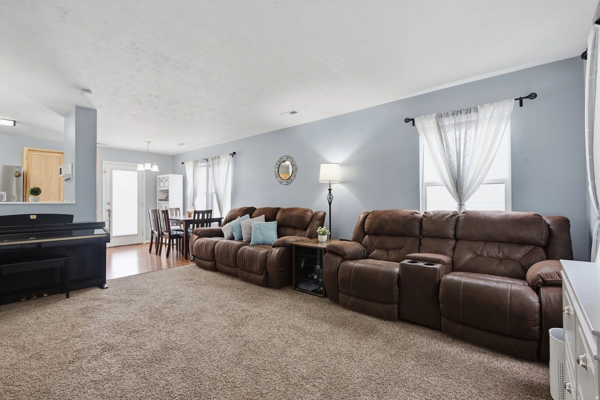 Carpeted living area with light blue walls and a white ceiling
