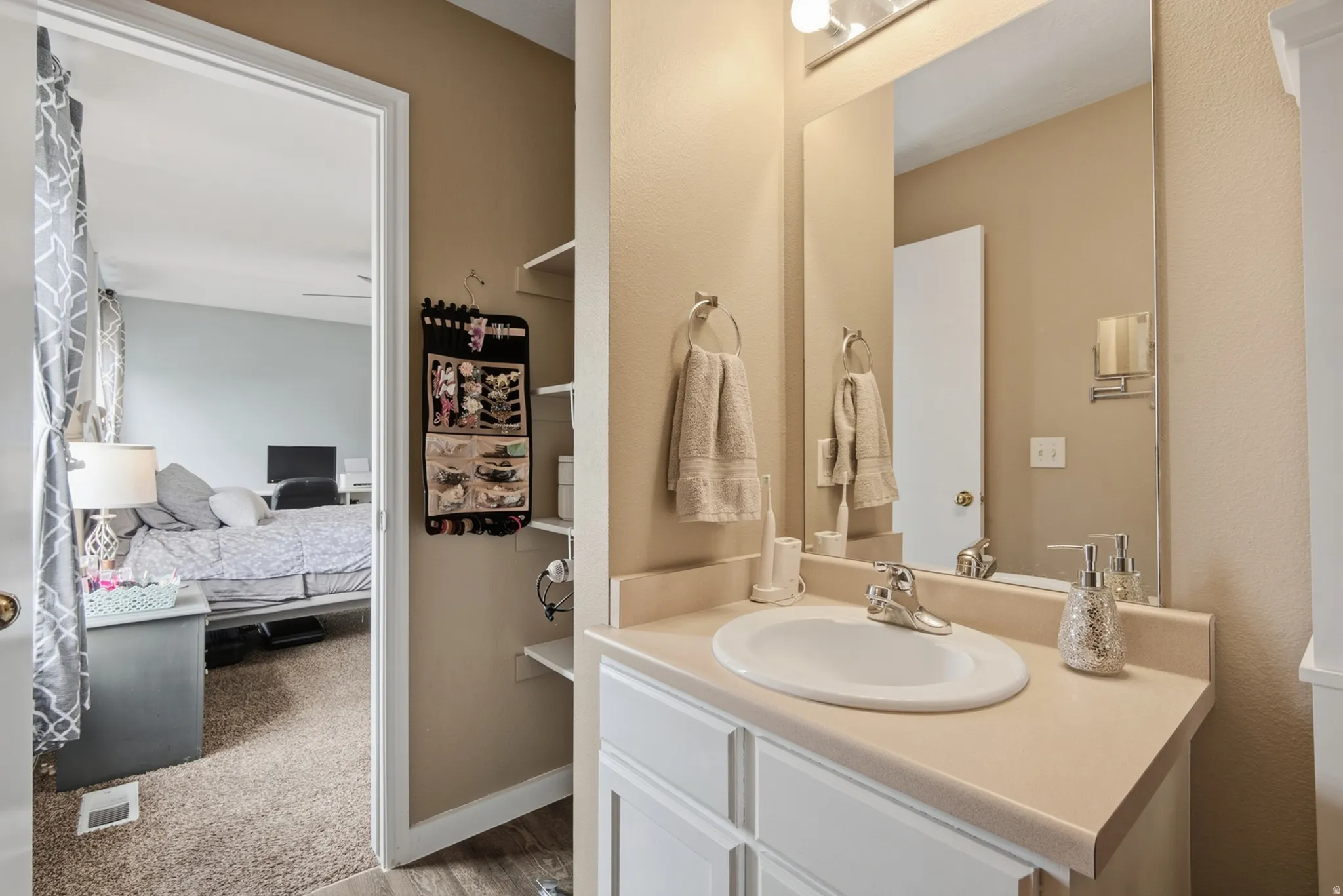 Bathroom vanity with a built-in sink, chrome faucet, and expansive mirror