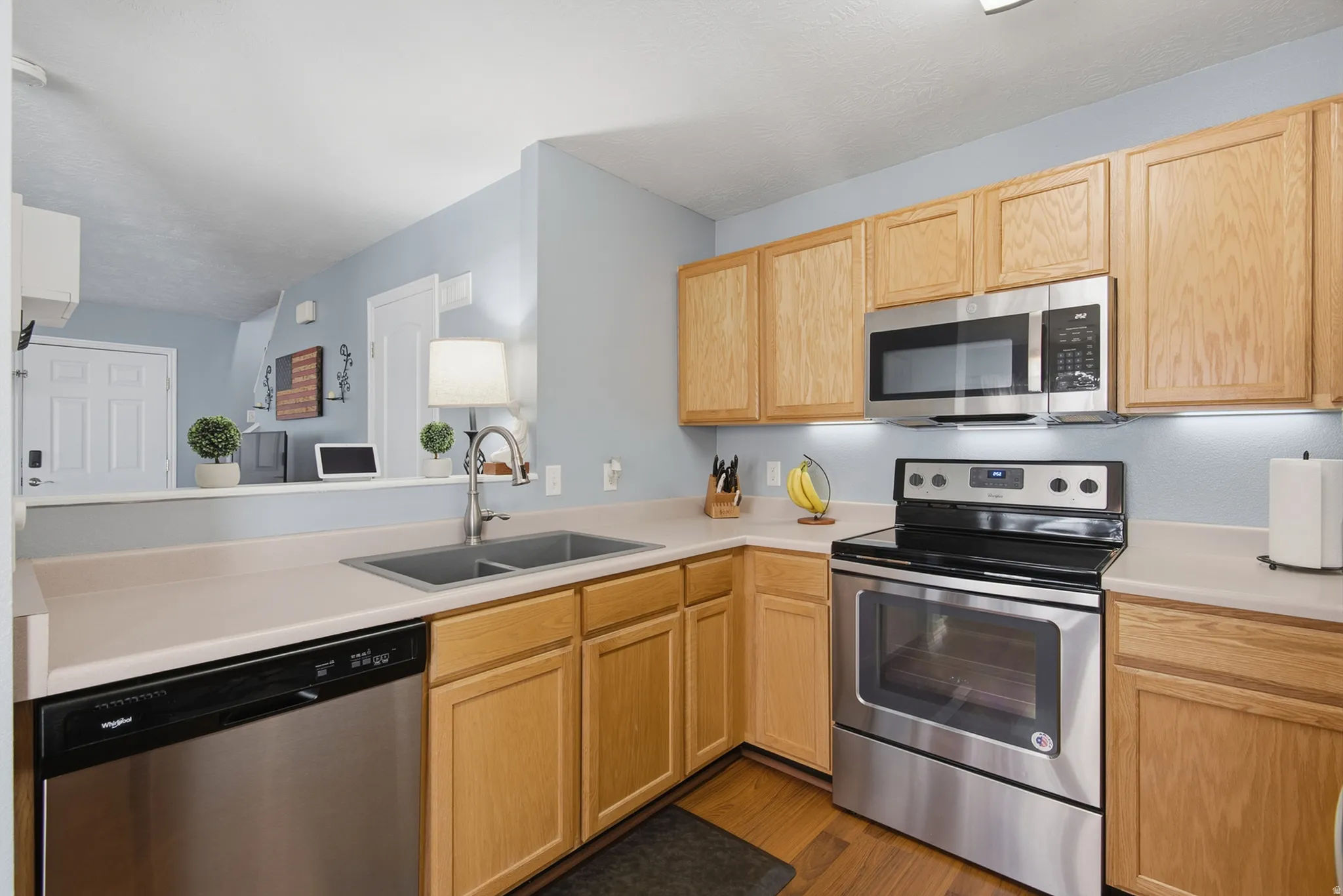 Kitchen featuring wood-finish cabinetry, stainless steel appliances, and a double basin sink