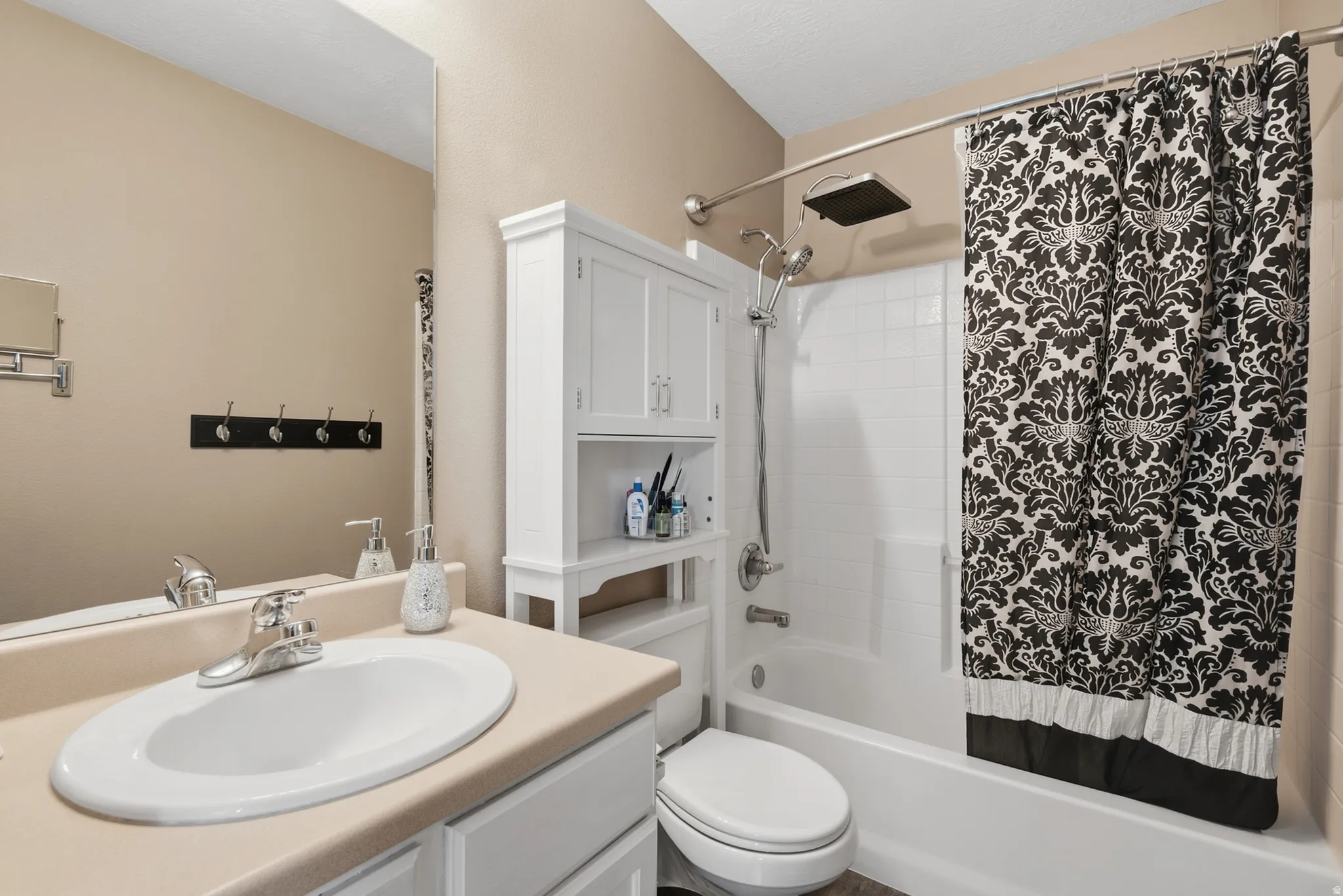 White vanity with integrated sink, chrome faucet, and expansive wall mirror