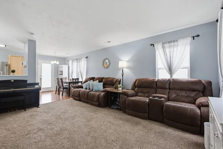 Carpeted living area with light blue walls and a white ceiling