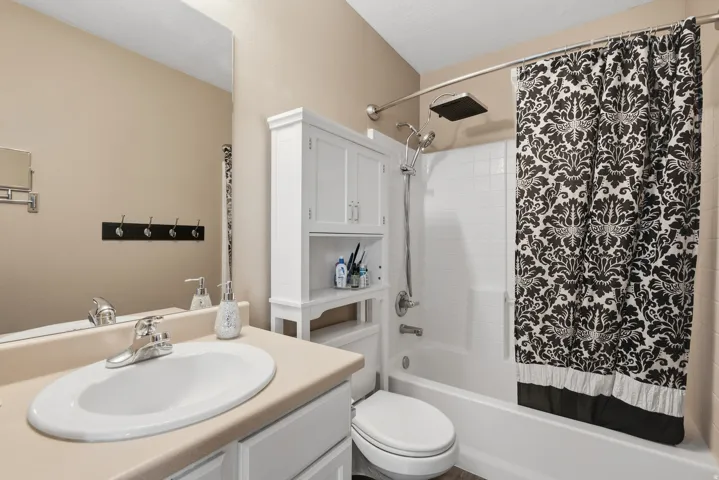 White vanity with integrated sink, chrome faucet, and expansive wall mirror