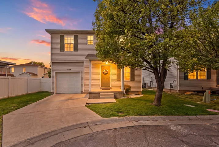 Two-story residence featuring horizontal siding, an attached single-car garage, a concrete driveway, and a fenced side yard