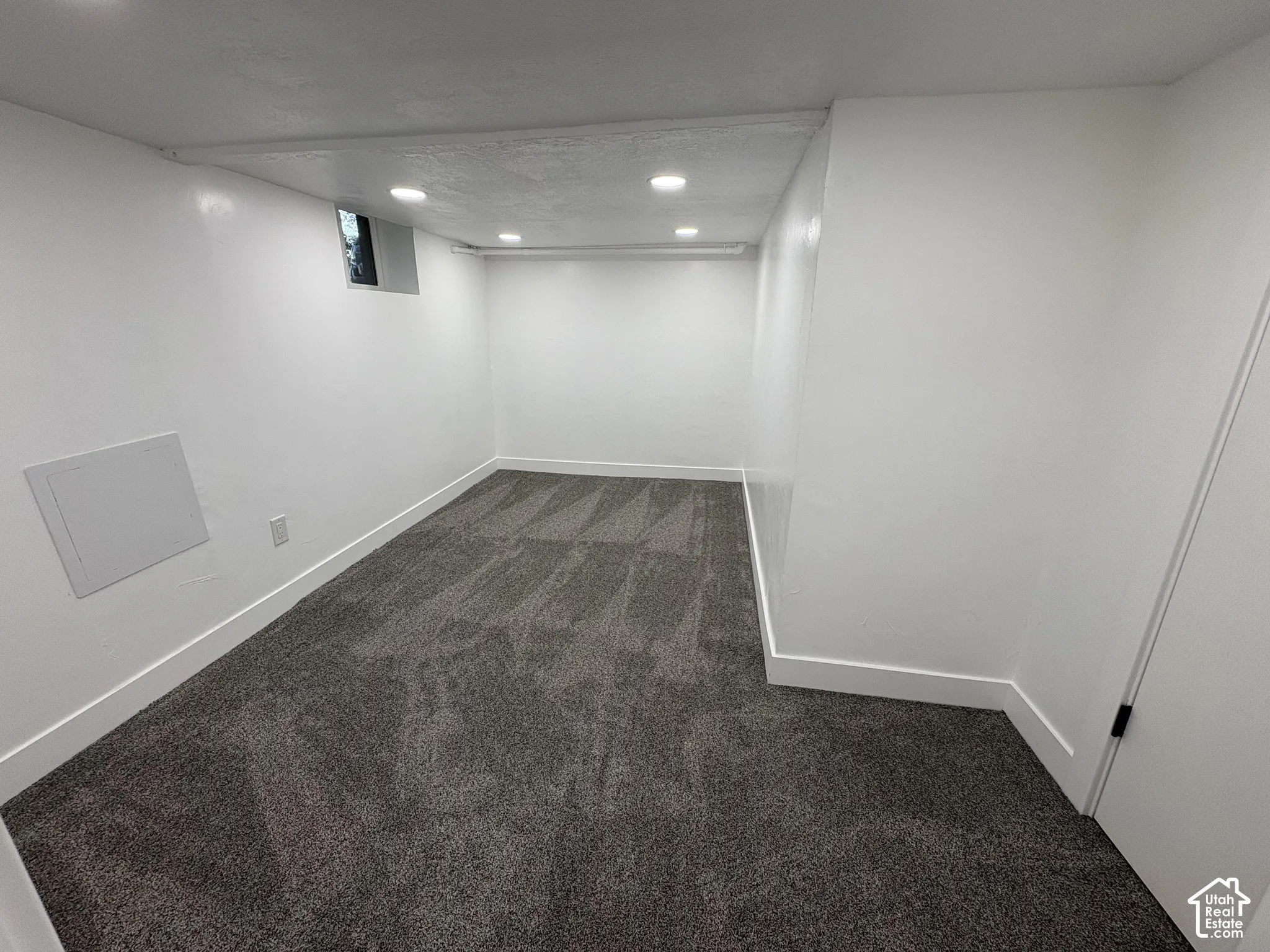 Recessed lighting illuminates the room with gray patterned carpet