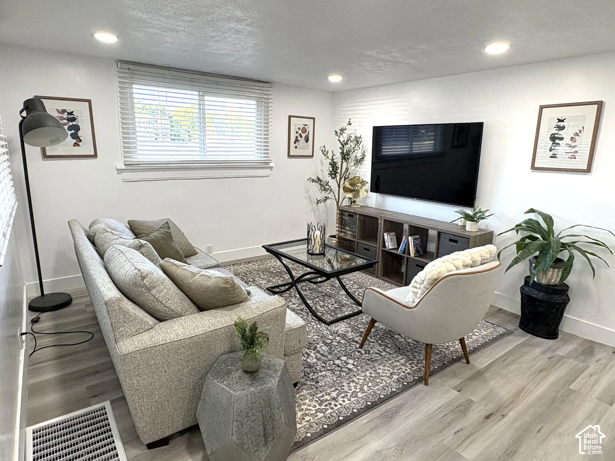 Recessed lighting, wood-finish flooring, and a window with blinds