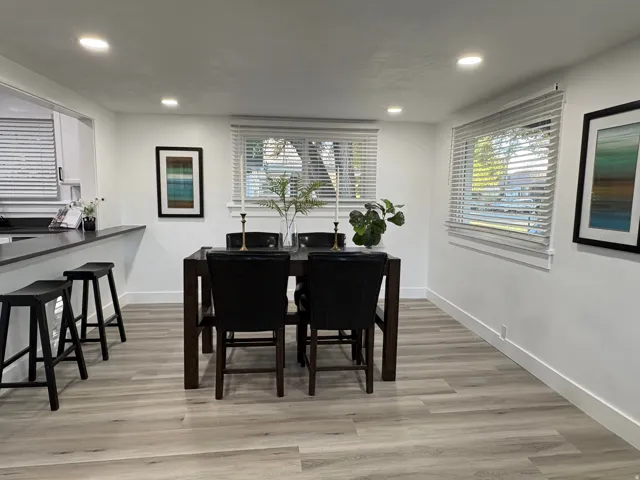 Recessed lighting, wood-finish flooring, white walls, and multiple windows with blinds