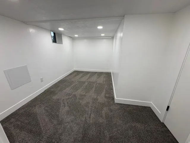 Recessed lighting illuminates the room with gray patterned carpet