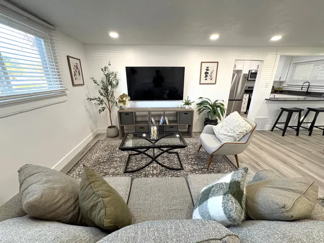 Recessed lighting illuminates the living space featuring wood-finish flooring