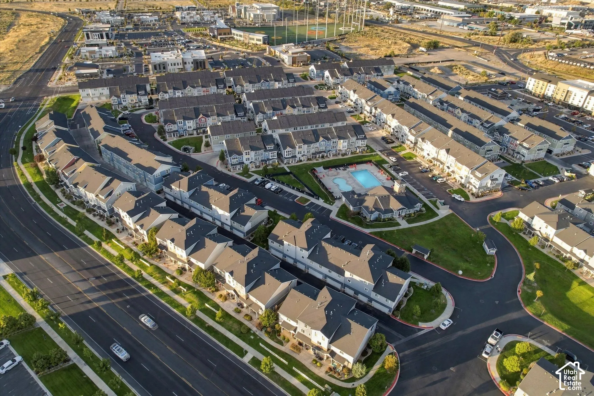 Community featuring a central swimming pool, paved roadways, green spaces, and dense residential housing