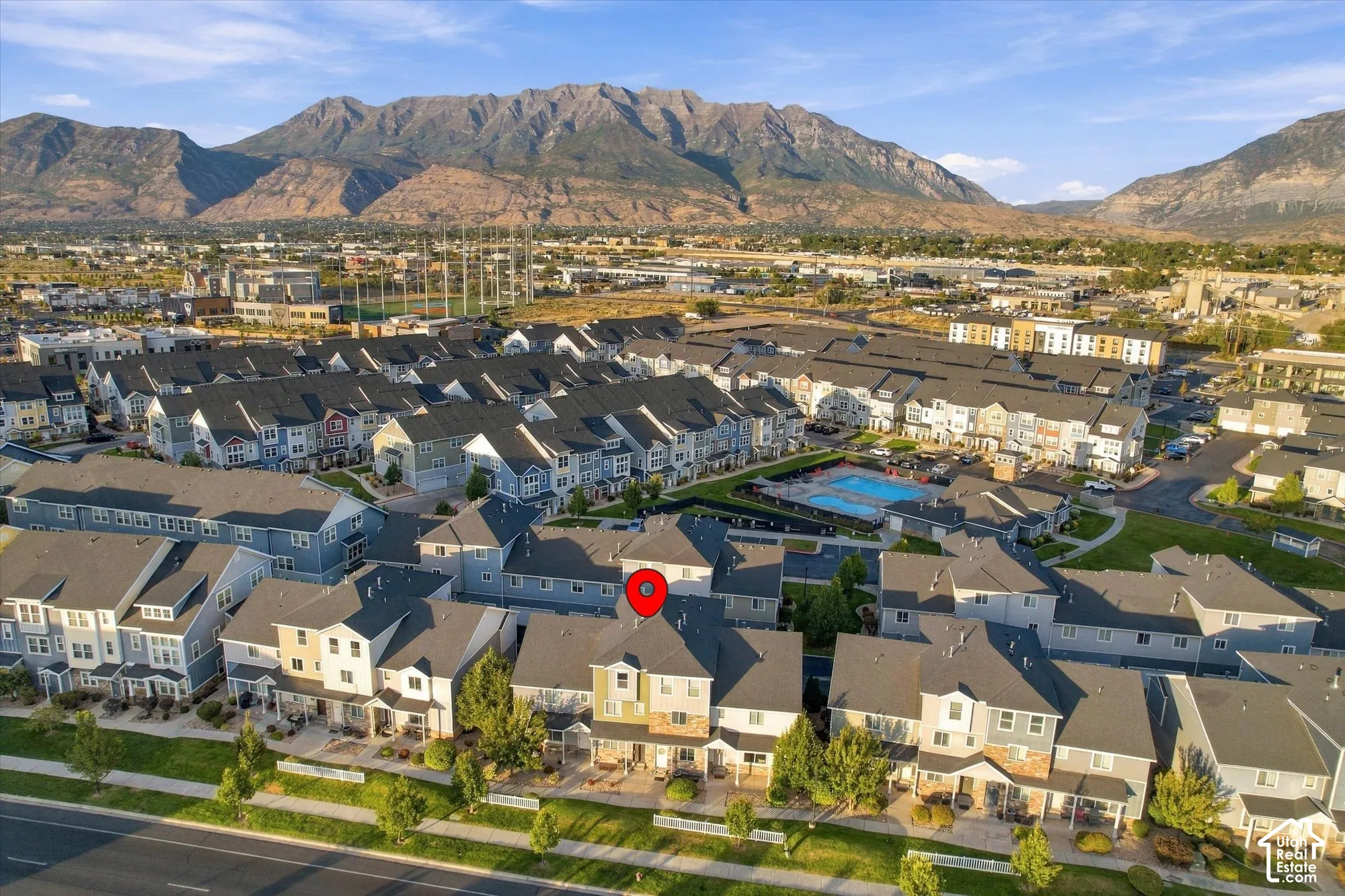 Aerial perspective of a multi-unit residential development with mountainous terrain backdrop
