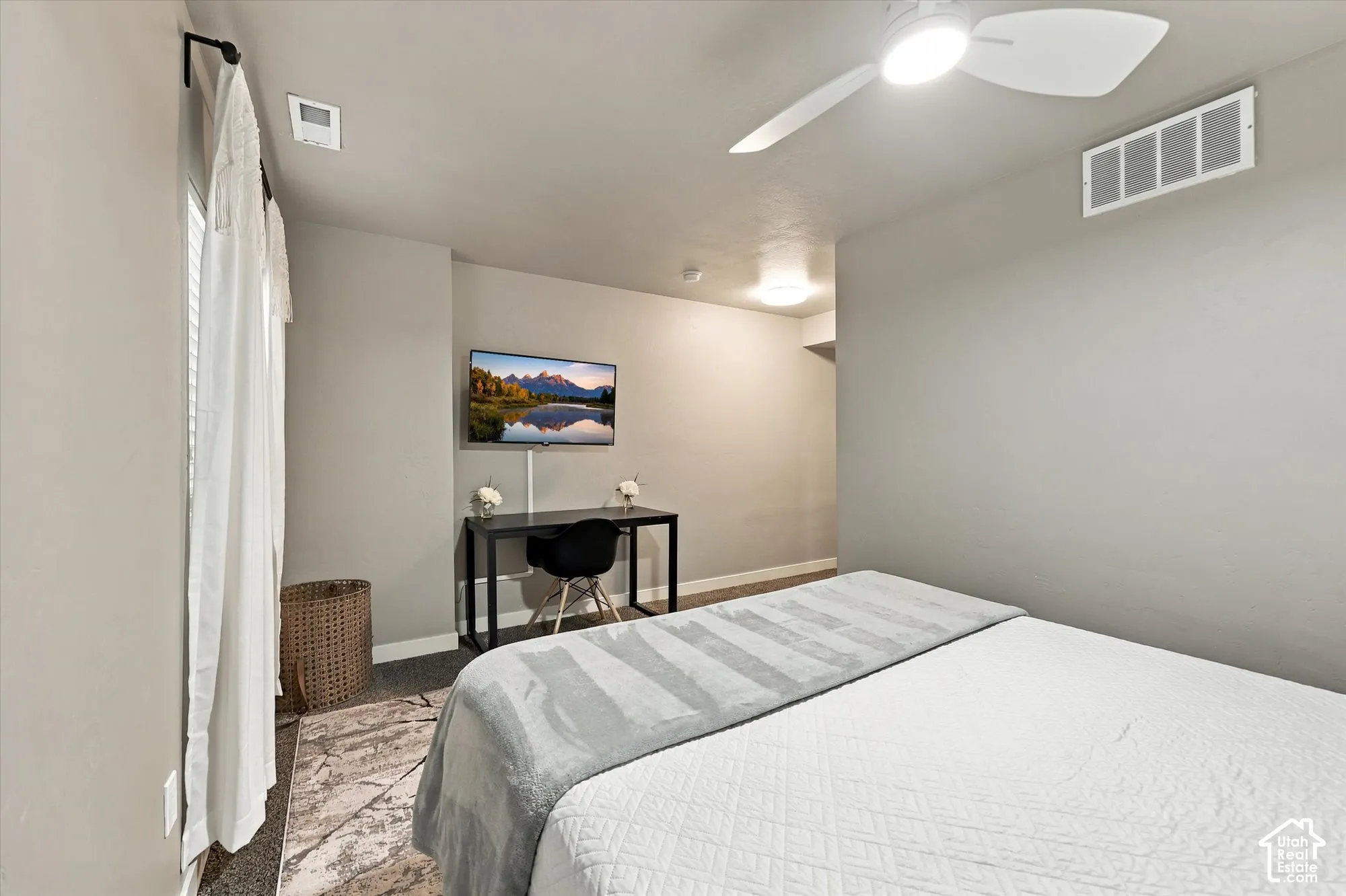 Wall-mounted television, ceiling fan, window with curtain rod, and recessed lighting
