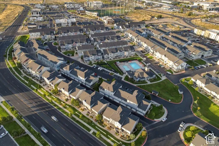 Community featuring a central swimming pool, paved roadways, green spaces, and dense residential housing