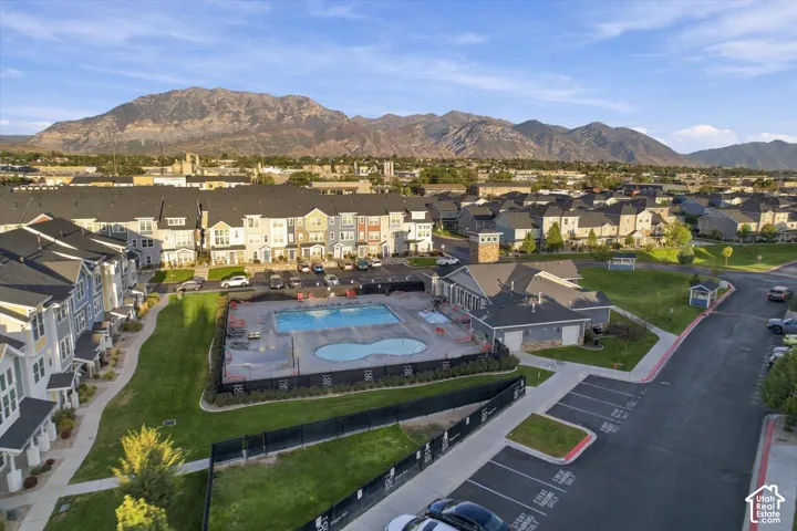 Community featuring a mountain backdrop, a communal swimming pool, and an adjacent community building