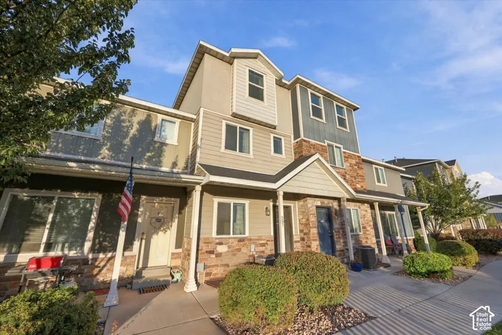 Multi-story townhome with varied siding and stone veneer accents