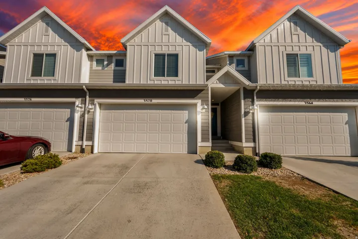 Contemporary townhome exterior with board and batten siding, attached garages, and concrete driveways