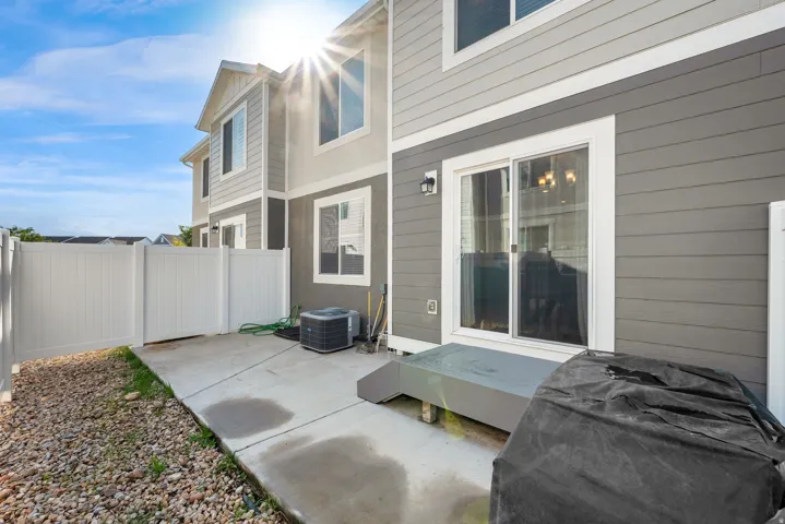 Exterior featuring gray siding, white trim, and a concrete patio