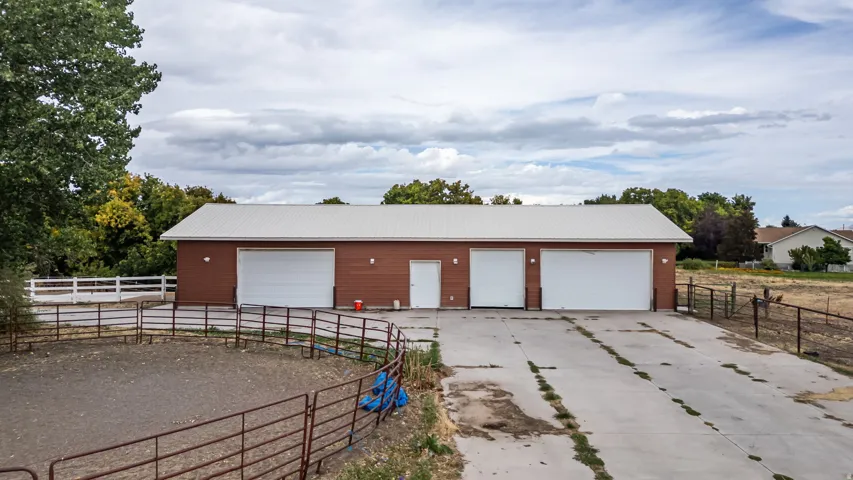 Detached accessory building with three garage bays, a pedestrian door, and a metal roof