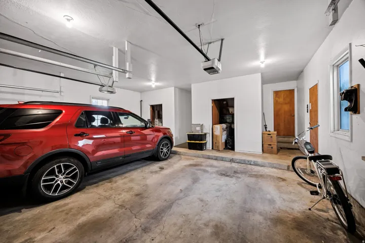 Attached two-car garage featuring a concrete floor, white painted walls, and overhead lighting