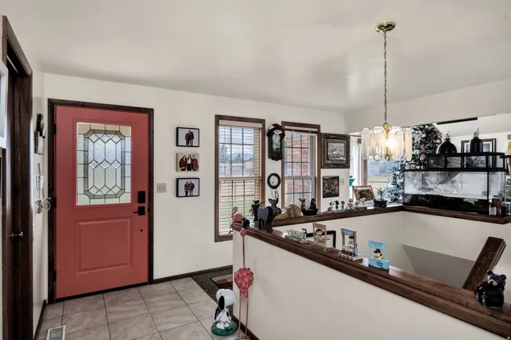 Entryway featuring a prominent leaded glass door, tile flooring, and a decorative chandelier