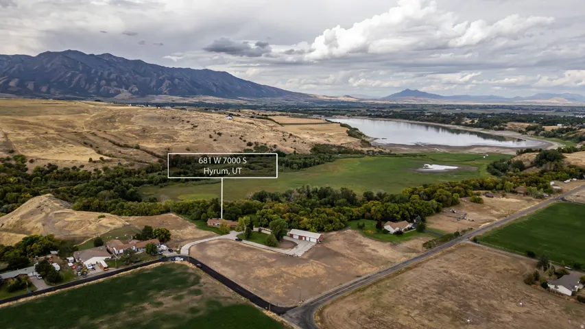 Expansive landscape featuring a body of water, distant mountains, and green terrain