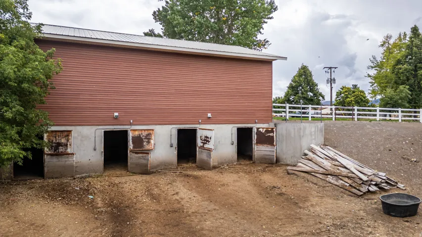 Barn structure featuring a metal roof, horizontal siding, and multiple ground-level entry points