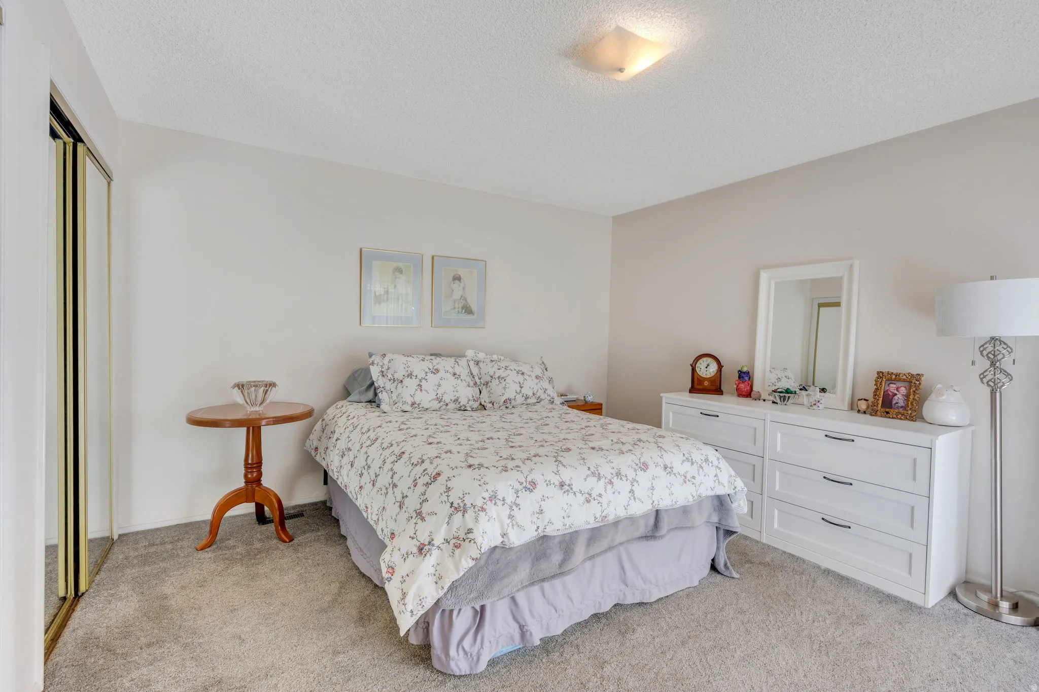 Plush wall-to-wall carpeting, neutral wall colors, and a ceiling-mounted light fixture
