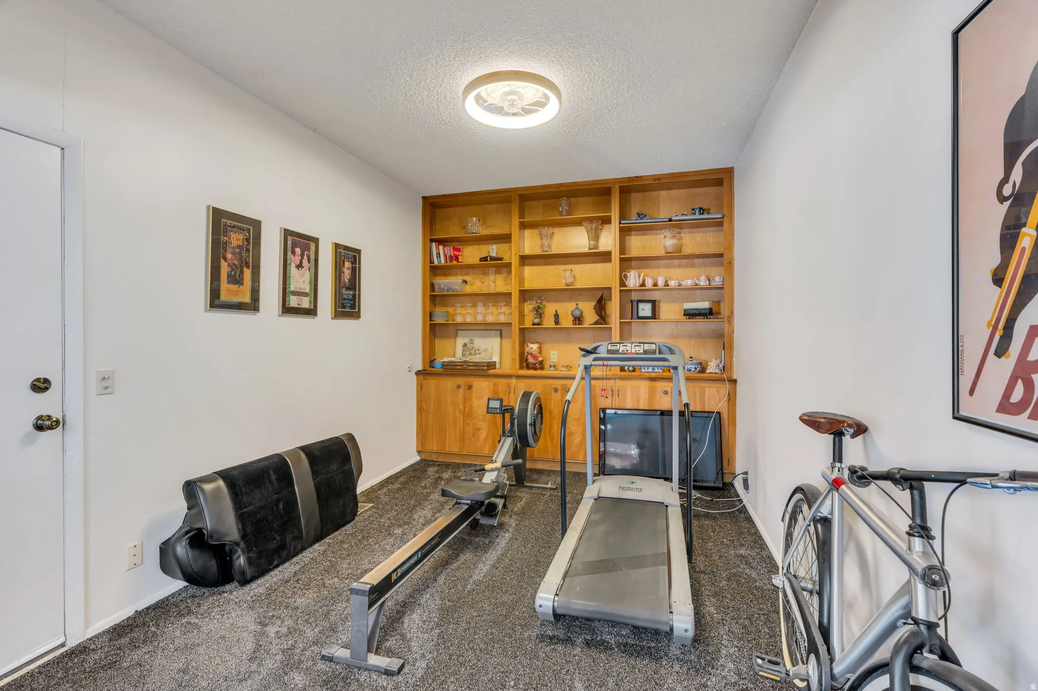 Room featuring a built-in wood cabinet with open shelving, recessed lighting, and textured ceiling