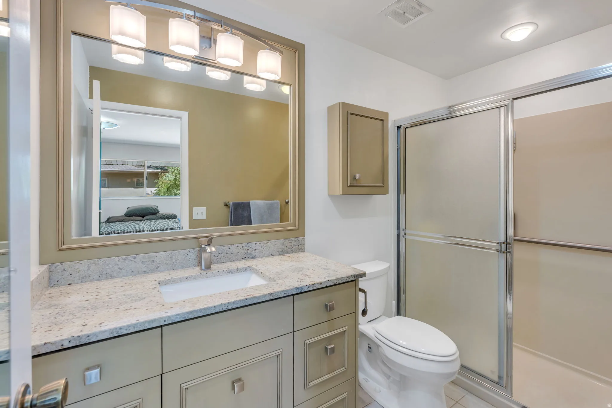 Vanity with a light-colored countertop, undermount sink, and brushed nickel faucet
