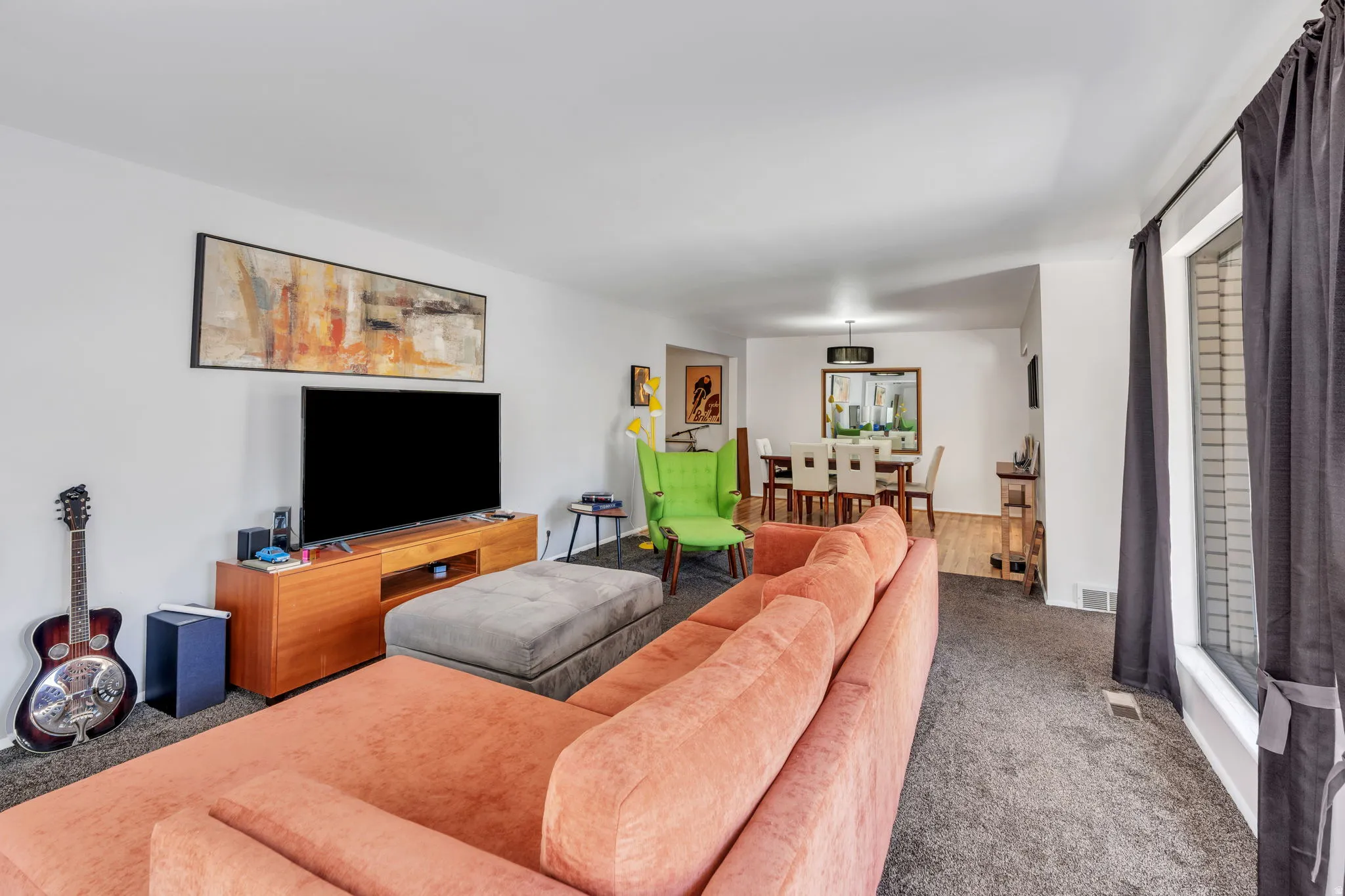 Spacious living area featuring carpet flooring and white walls