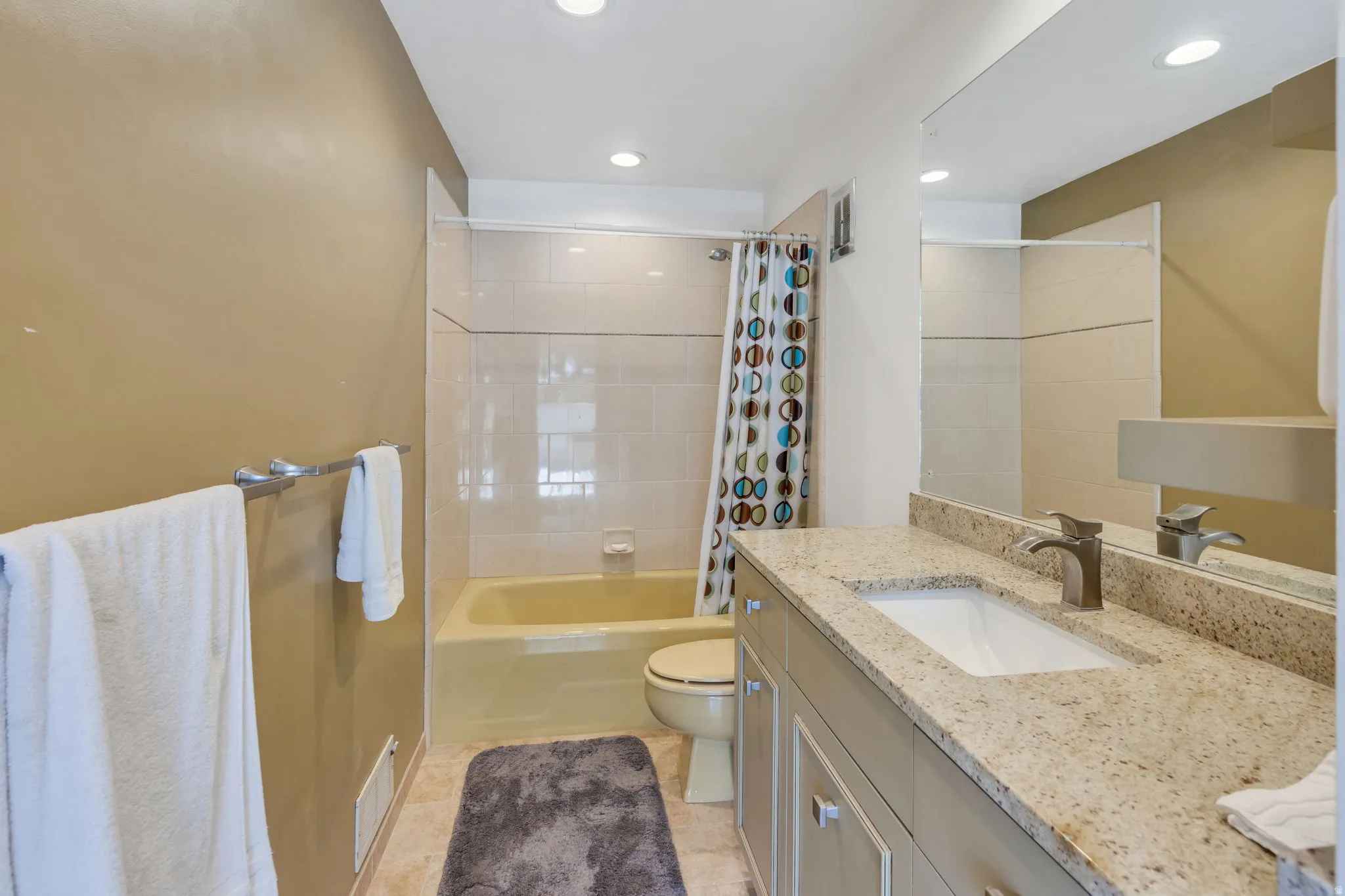 Granite-finish countertop with an undermount sink, brushed nickel faucet, and a full-width mirror