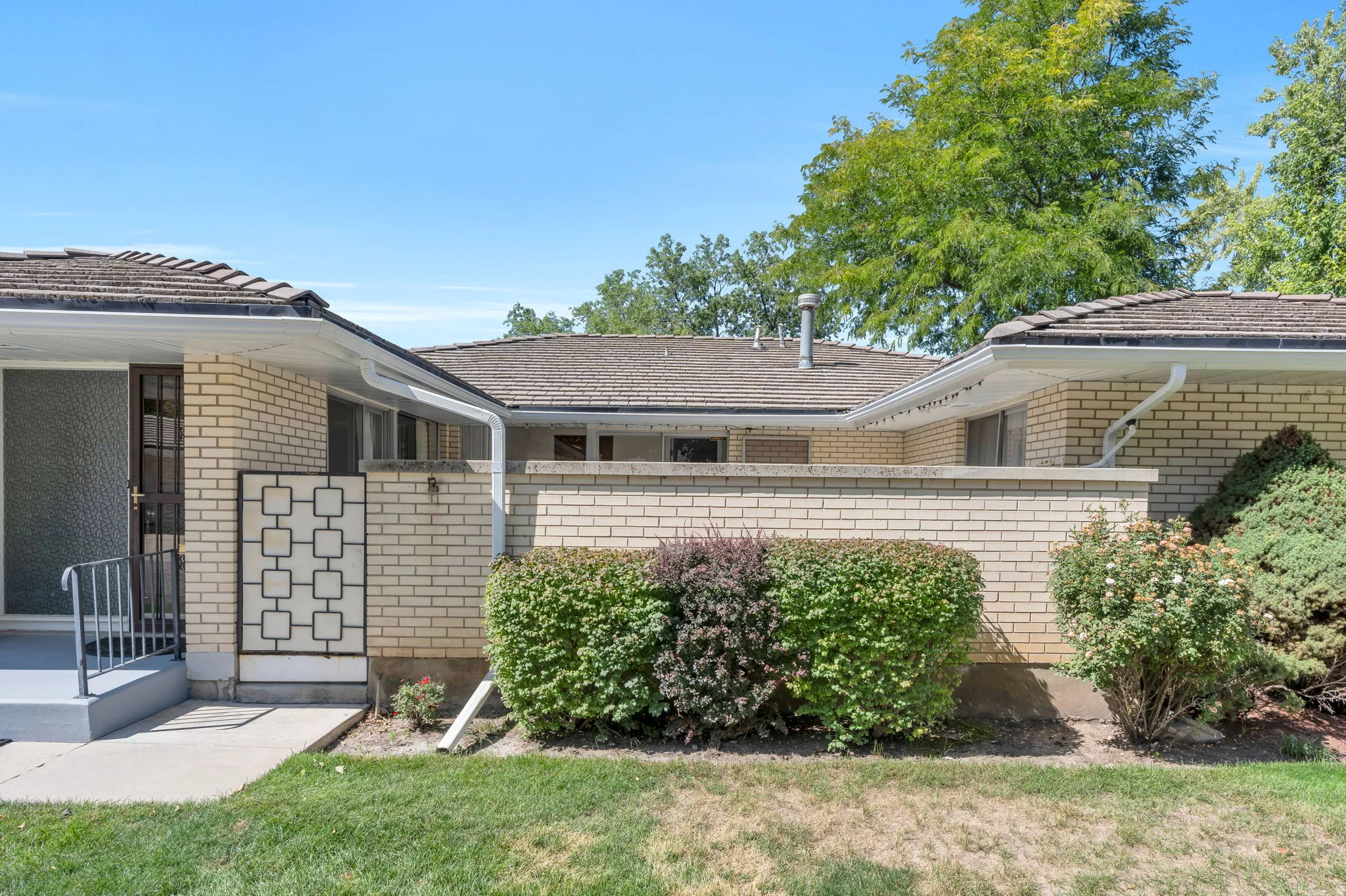Brick exterior with a covered entry and decorative security gate